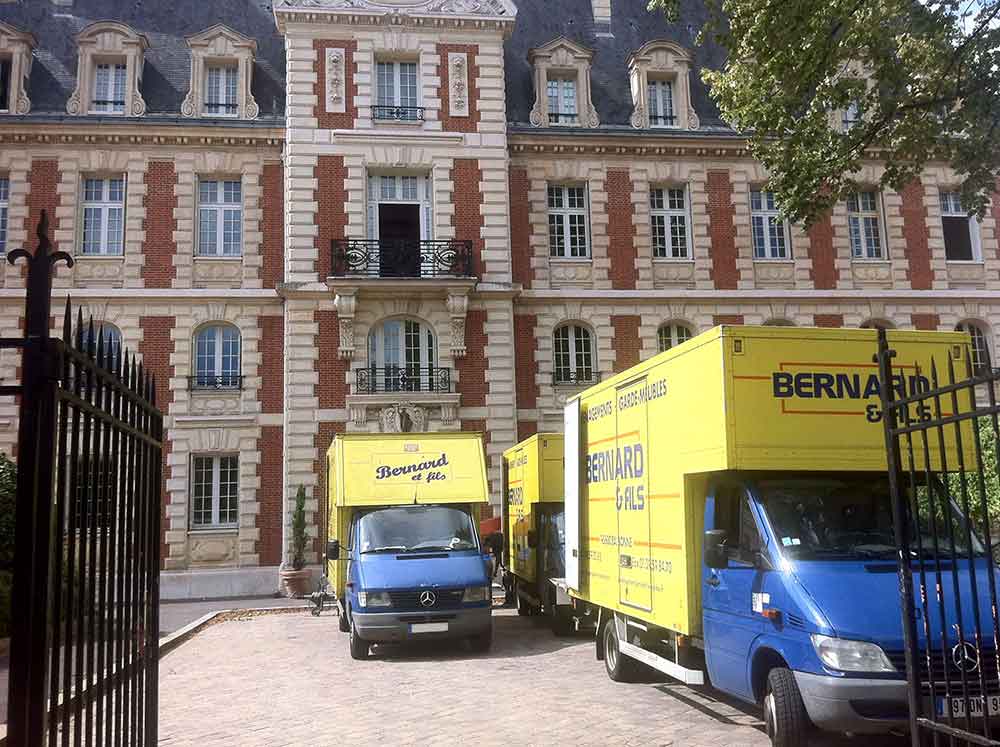 Déménagements pour particuliers et professionnel dans le Val d'Oise (95) avec Bernard et Fils Camions de l'entreprise de déménagement Bernard et Fils jaune et bleu lors d'un déménagement dans la cours d'une propriété